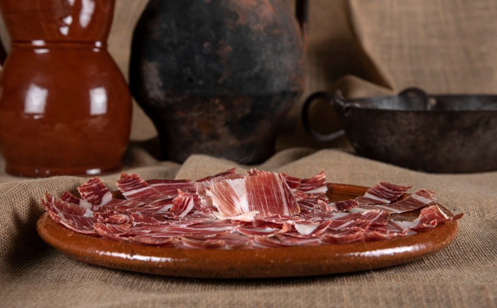 Jamón ibérico emplatado sobre cerámica tradicional